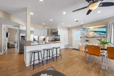 a kitchen and living room with a table and chairs at Steps to Beach AC Parking Beach Equipment in Newport Beach