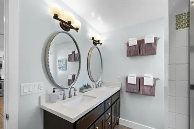 a bathroom with a sink and two mirrors at Steps to Beach AC Parking Beach Equipment in Newport Beach