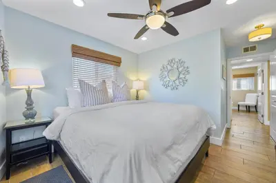 a bedroom with a white bed and a ceiling fan at Steps to Beach AC Parking Beach Equipment in Newport Beach