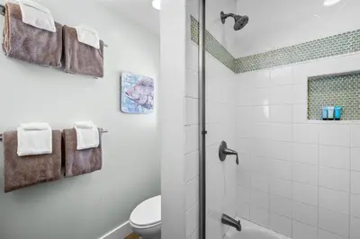 a white bathroom with a shower and a toilet at Steps to Beach AC Parking Beach Equipment in Newport Beach