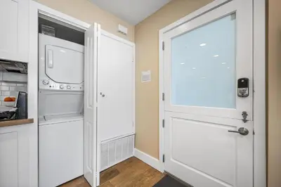 a kitchen with a white door and a washer and dryer at Steps to Beach AC Parking Beach Equipment in Newport Beach