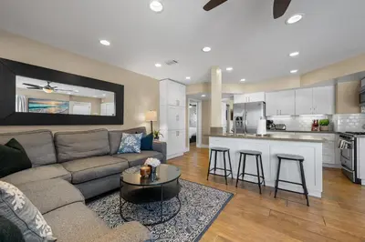 a living room with a couch and a kitchen at Steps to Beach AC Parking Beach Equipment in Newport Beach