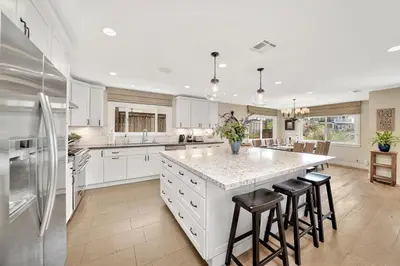 a kitchen with white cabinets and a large island with bar stools at Monthly 4BD4BA LuxuryHot TubPool TableYard in San Clemente