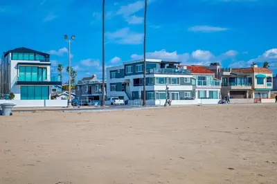 a group of houses on the beach with a sandy beach at Steps to SandParkingACGround Level in Newport Beach