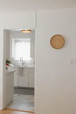 a kitchen with white cabinets and a sink at Designer Bungalow Steps to Beach in San Diego