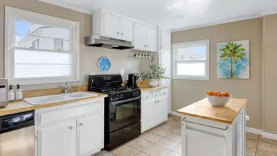 a kitchen with white cabinets and a black stove at The Edgewater Condos by AvantStay in Newport Beach