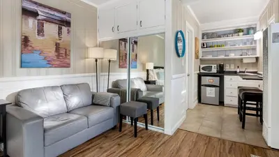 a living room with a couch and a kitchen at The Edgewater Condos by AvantStay in Newport Beach