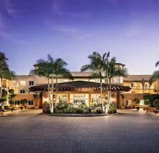a large building with palm trees in front of it at Grand Pacific Palisades Resorts in Carlsbad