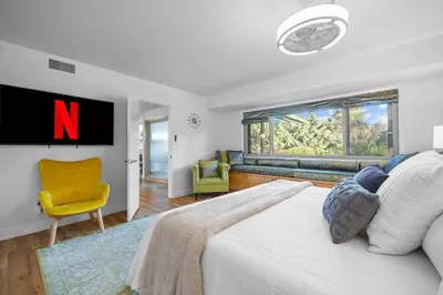 a bedroom with a large bed with a n on the wall at Nature-Inspired Stay with Pool, Fire Pits and More in El Cajon
