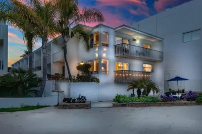 a white house with palm trees in front of it at Bayfront Oasis Close to Boardwalk and Water in San Diego