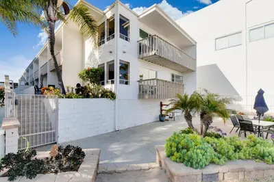 a white house with palm trees and a patio at Bayfront Oasis Close to Boardwalk and Water in San Diego