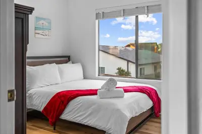 a bedroom with a bed with a red blanket and a window at Mira Mesa Family Retreat 4BR with Balcony and Firepit in San Diego