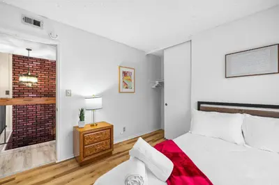 a bedroom with a white bed and a brick wall at Mira Mesa Family Retreat 4BR with Balcony and Firepit in San Diego