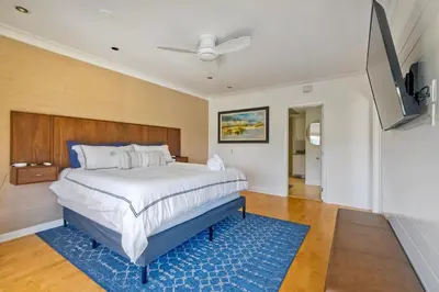 a bedroom with a large bed with a blue rug at Pool, Hot Tub, Steps To Omni La Costa in Carlsbad