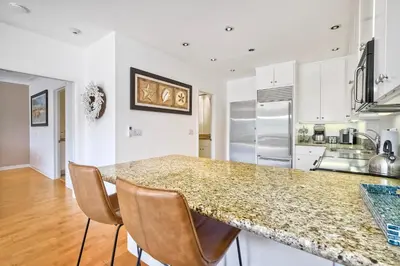 a kitchen with a granite counter top and a kitchen island at Pool, Hot Tub, Steps To Omni La Costa in Carlsbad