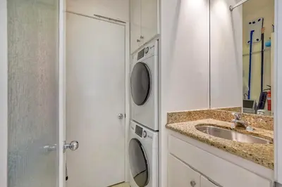 a bathroom with a sink and a washing machine at Pool, Hot Tub, Steps To Omni La Costa in Carlsbad