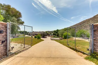 a chain link fence with a gate on a sidewalk at Family Hideaway with Hillside Views in Temecula! in Temecula