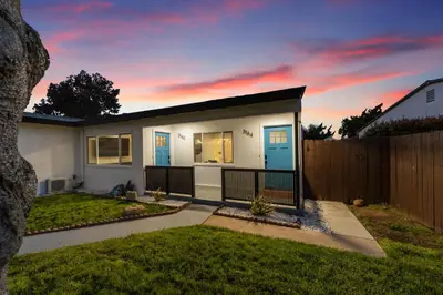 a small white house with a fence at 2BR, 2B, Coffee Bar, Cozy Sectional, Rainfall Shower, Smart TVs, Cozy Beach Theme in San Diego