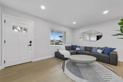 a living room with a couch and a table at 2BR, 2B, Coffee Bar, Cozy Sectional, Rainfall Shower, Smart TVs, Cozy Beach Theme in San Diego