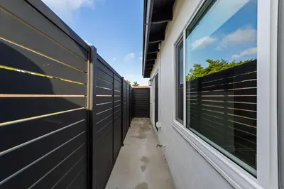 a hallway of a house with a fence at 2BR, 2B, Coffee Bar, Cozy Sectional, Rainfall Shower, Smart TVs, Cozy Beach Theme in San Diego