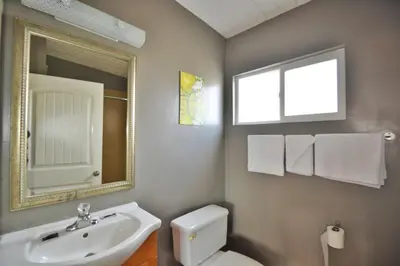 a bathroom with a sink and a toilet and a mirror at Lodge at 32nd in San Diego