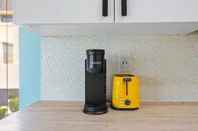 a black and yellow appliance sitting on a kitchen counter at Charming Coastal Retreat in Solana Beach in Solana Beach