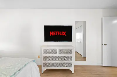 a white dresser with a tv on it in a bedroom at Charming Coastal Retreat in Solana Beach in Solana Beach