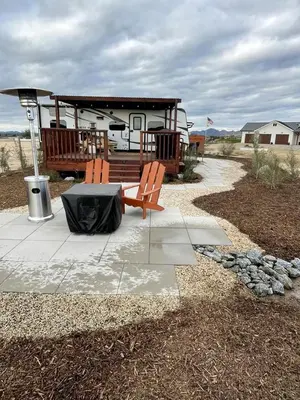 a rv with a table and two chairs on a patio at Cozy Camper with Fire Pit and Beautiful Sunsets in California in Temecula