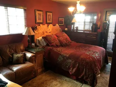 a bedroom with a bed and a couch and a chair at Grand Rustic Cabin Rental with Private Hot Tub near Escondido, California in Julian