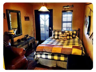 a bedroom with a bed and a mirror and a chair at Grand Rustic Cabin Rental with Private Hot Tub near Escondido, California in Julian