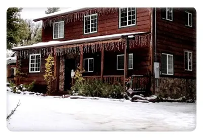 a house with icicles on it in the snow at Grand Rustic Cabin Rental with Private Hot Tub near Escondido, California in Julian