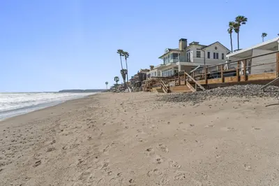 a beach with houses and footprints in the sand at Private beach toes on the Sand Waterworld in Dana Point