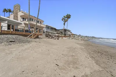 a sandy beach with houses and palm trees at Private beach toes on the Sand Waterworld in Dana Point