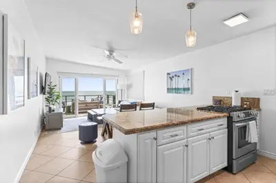 a kitchen with white cabinets and a counter top at Private beach toes on the Sand Waterworld in Dana Point