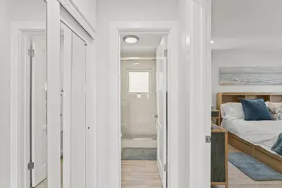 a bedroom with a bed and a walk in shower at Penthouse Steps from Victoria Beach 180 degree ocean views in Laguna Beach