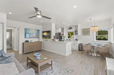 a white living room with a couch and a table at Penthouse Steps from Victoria Beach 180 degree ocean views in Laguna Beach