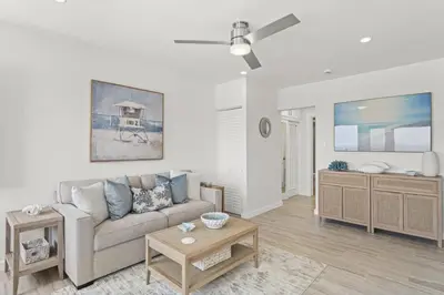 a living room with a couch and a table at Penthouse Steps from Victoria Beach 180 degree ocean views in Laguna Beach