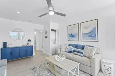 a living room with a couch and a ceiling fan at Penthouse Steps from Victoria Beach 180 degree ocean views in Laguna Beach