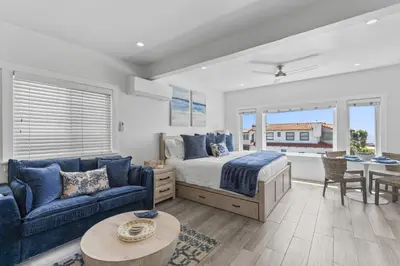 a bedroom with a bed and a couch and a table at Ocean VIEWS Steps from Victoria Beach Lux Design in Laguna Beach