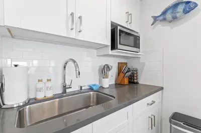 a kitchen with a sink and a microwave at Ocean VIEWS Steps from Victoria Beach Lux Design in Laguna Beach