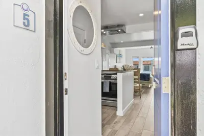 a hallway with a door leading to a kitchen at Ocean VIEWS Steps from Victoria Beach Lux Design in Laguna Beach