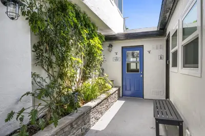 a house with a blue door and a bench at Ocean VIEWS Steps from Victoria Beach Lux Design in Laguna Beach
