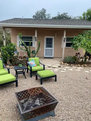 a patio with chairs and a fire pit in front of a house at Rustic Ridge Vineyards Cottage in Jamul