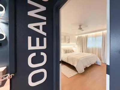 a bedroom with a bed and a sign that says hotel at Fully Renovated Beachfront Surf House Oceanside in Oceanside