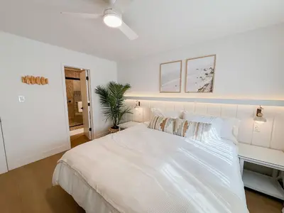 a white bedroom with a large bed and a desk at Fully Renovated Beachfront Surf House Oceanside in Oceanside