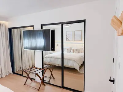 a bedroom with a bed and a mirror at Fully Renovated Beachfront Surf House Oceanside in Oceanside