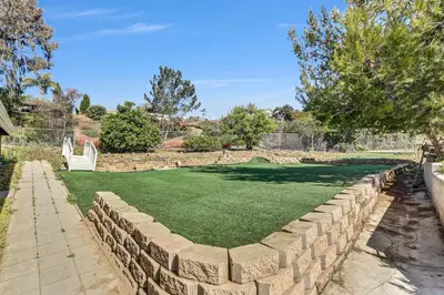 a retaining wall in a yard with a artificial lawn at 16 Plus ADU Solana Beach DelMar Fair in Encinitas