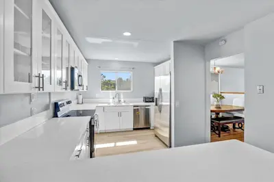 a white kitchen with a sink and a table at 16 Plus ADU Solana Beach DelMar Fair in Encinitas