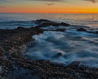 a group of rocks in the ocean at sunset at Modern Laguna Beach Duplex - Prime Location! in Laguna Beach