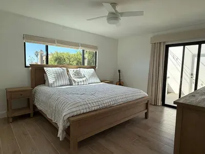 a bedroom with a bed with a ceiling fan at Modern Laguna Beach Duplex - Prime Location! in Laguna Beach